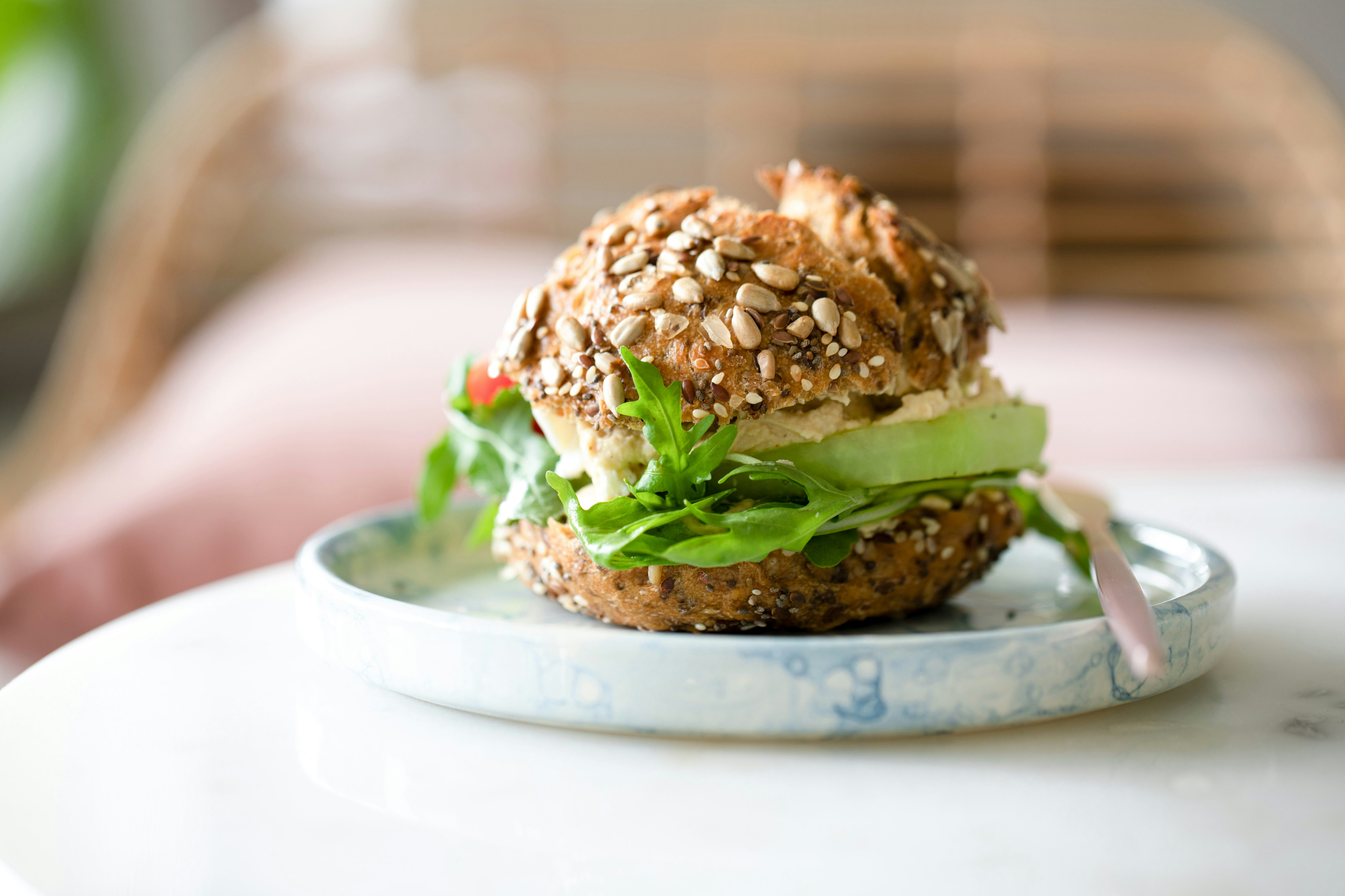burger with lettuce and tomatoes on white ceramic plate